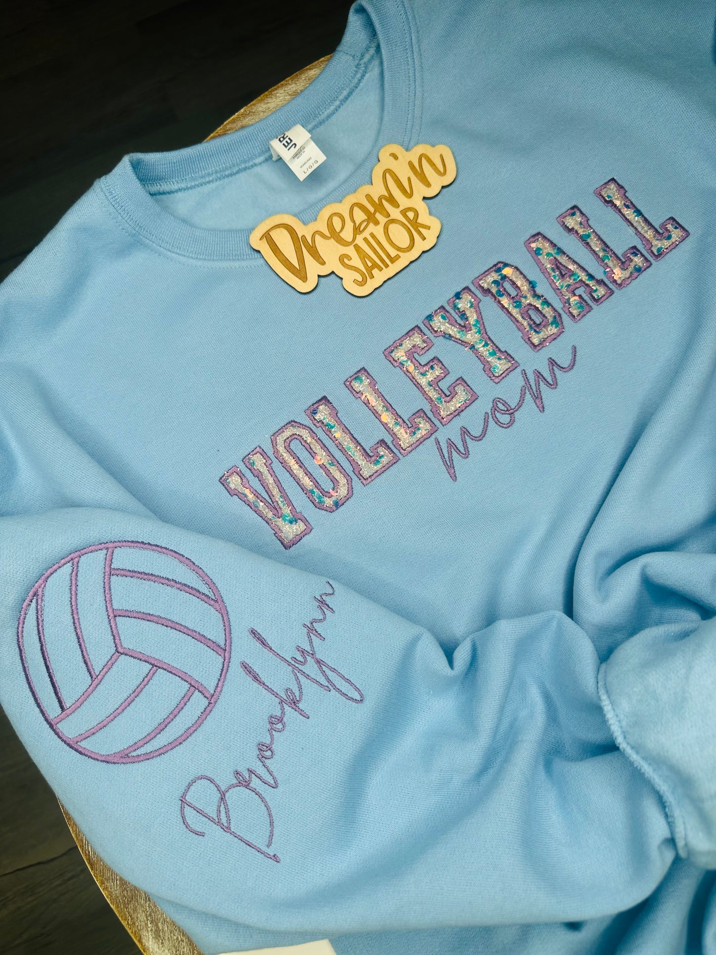 Volleyball Mom custom embroidery with sequins appliqué inside of Volleyball and player name on the sleeve.