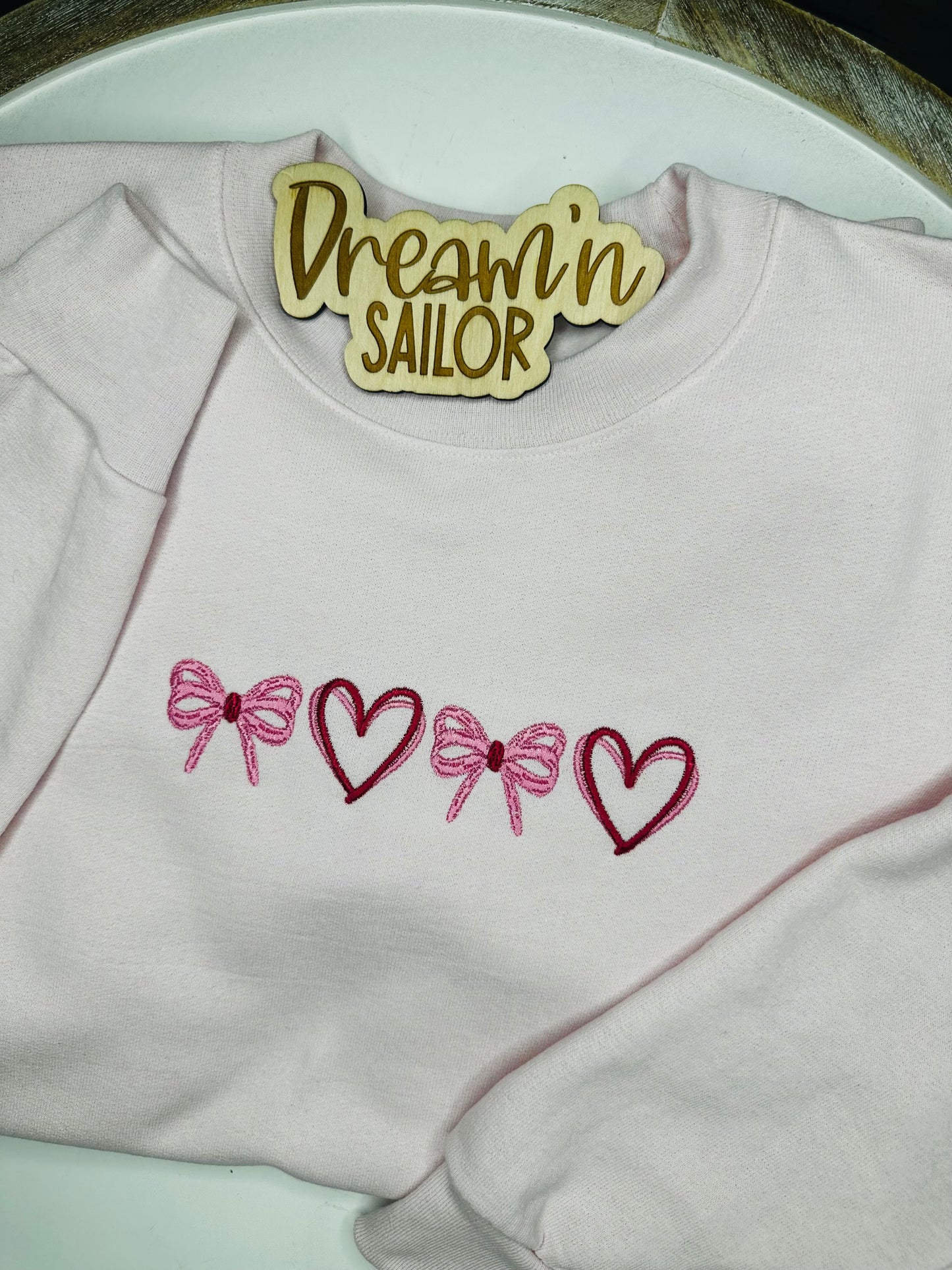 Bows and hearts embroidered on crewneck sweatshirt
