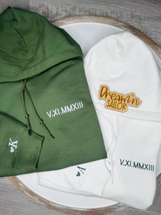 Anniversary date embroidered on left chest of the hoodie and a heart with initial embroidered on the sleeve.
